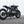 photo du côté d'une moto noire bmw cafe racer devant un mur blanc