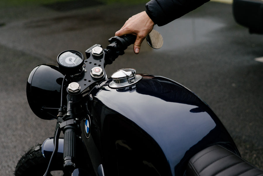 photo d'une main sur une moto bleue bmw cafe racer